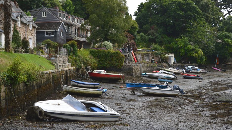 A quiet harbor lane on Iwaishima with small wooden fishing boats and laundry drying between old houses