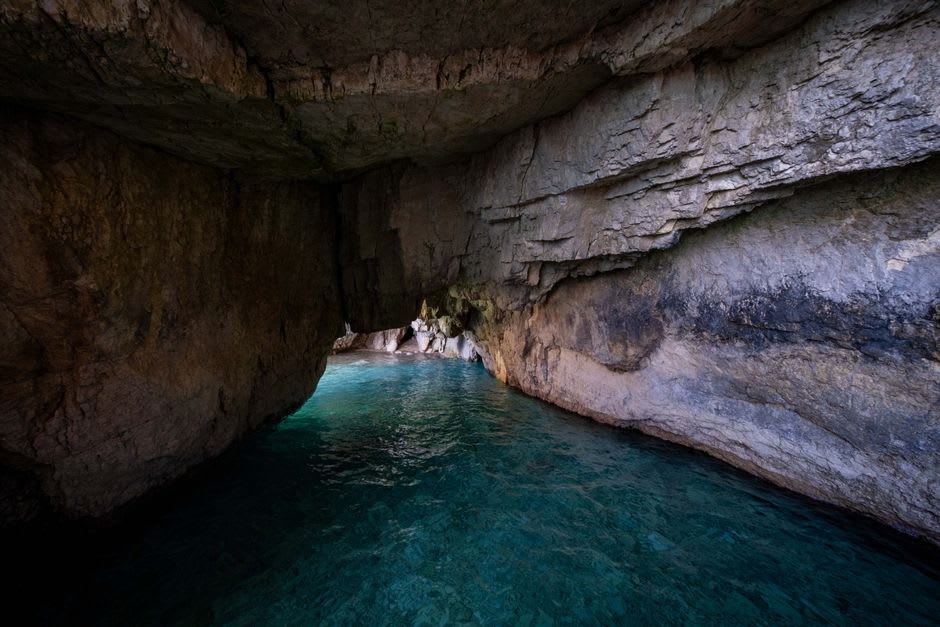 La lumière du soleil brillant d'un bleu profond à travers l'eau claire à l'intérieur de la grotte marine près de Jodogahama