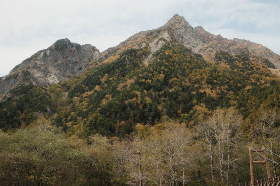 Les sommets d'Hotaka se reflétant dans la surface immobile de l'étang Taishō à Kamikōchi à l'aube, des arbres morts blanchis se dressant dans les eaux peu profondes