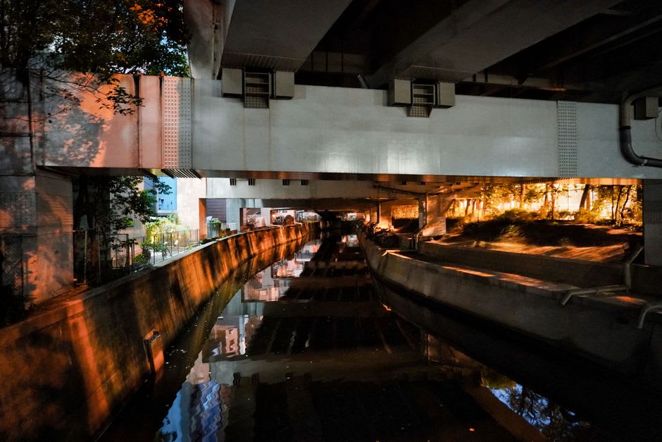 A quiet river-side street in Masuda with older wooden buildings under a soft afternoon light