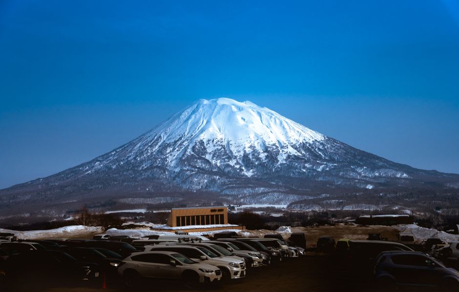 Le cône enneigé et symétrique du mont Yōtei s'élevant sans nuage au-dessus de la vallée près de Niseko, ses pentes rayonnant dans la lumière claire de l'après-midi