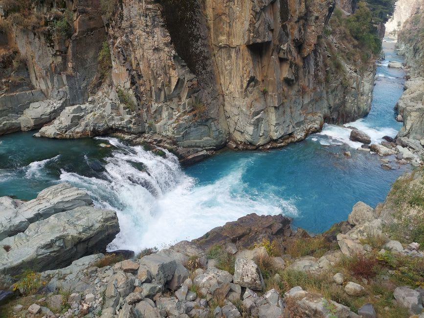 Flat-bottomed pleasure boat drifting beneath the striped rock walls of Ōboke gorge