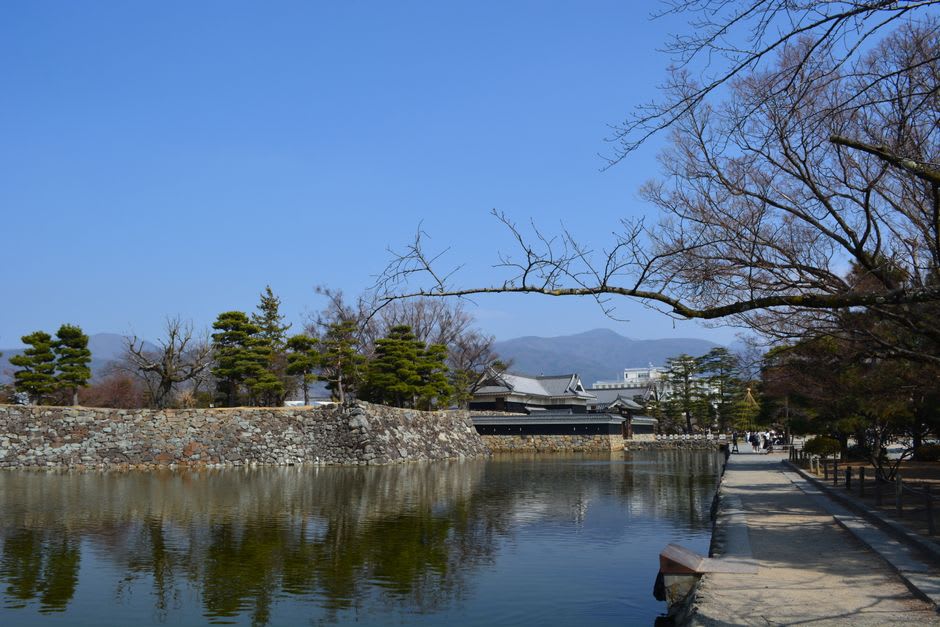 Un canal de source limpide plein de carpes orange longeant une rue à Shimabara