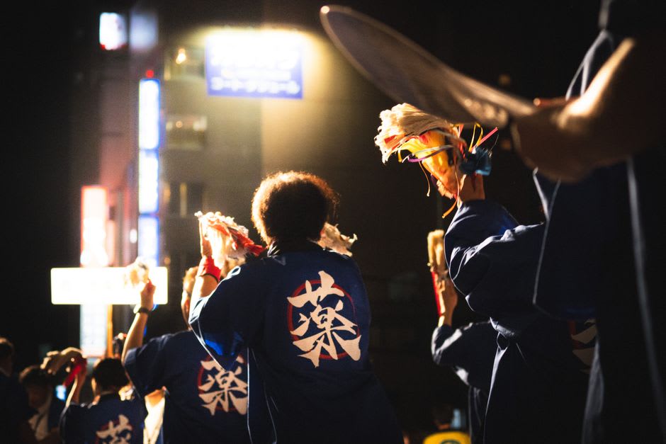 Awa Odori dancers with drums and lanterns filling a Tokushima street at night