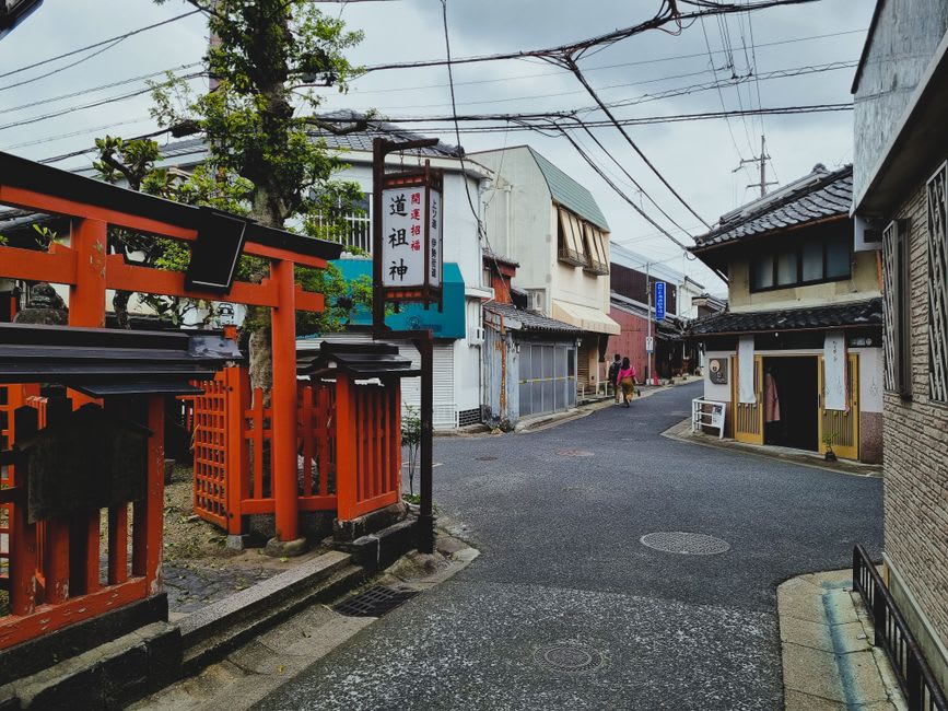 Une rue tranquille du village de Yahiko près de l'enceinte du sanctuaire, de petits daims se reposant sur l'herbe dans la lumière de fin d'après-midi