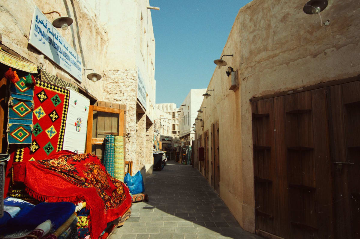 Étals d'épices au souq Mubarakiya avec des sacs ouverts de citron sec, de safran et de cardamome captant la lumière du matin