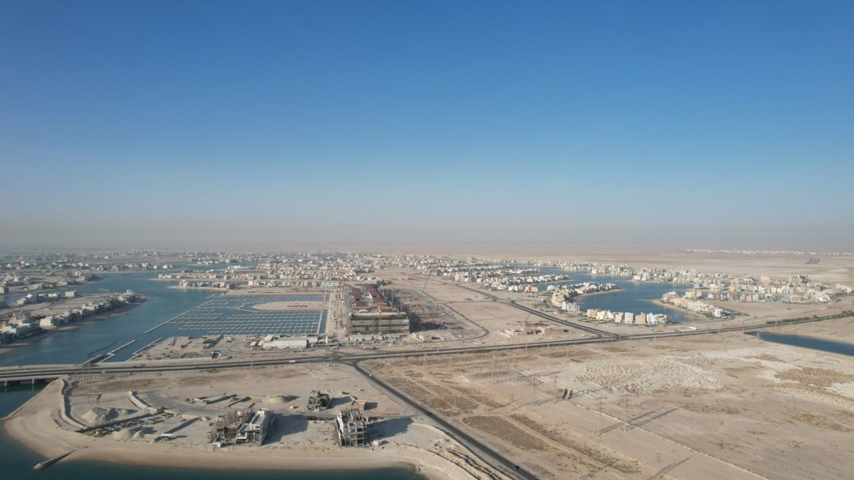 The broad panorama from Mutla Ridge looking south across Kuwait Bay with cargo ships visible on the distant Gulf water