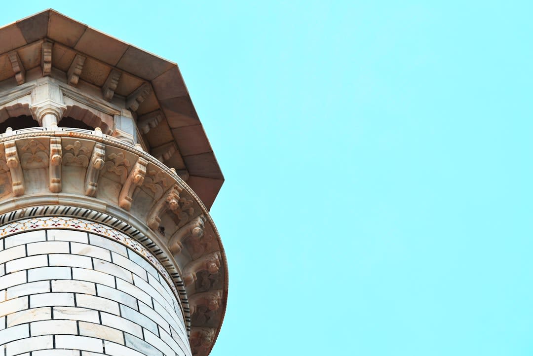 La torre de ladrillo de Burana contra un cielo azul intenso, con su sección superior desgastada mostrando daños por terremotos