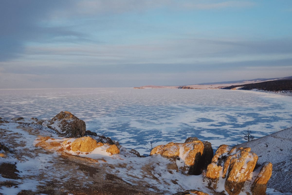 La rue principale de Severobaïkalsk sous la lumière du matin, des immeubles soviétiques en arrière-plan et les montagnes de la chaîne du Baïkal derrière