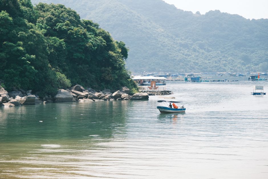 Un petit bateau en bois traversant le Lago Rupanco vers la rive sud boisée où se trouvent les sources chaudes