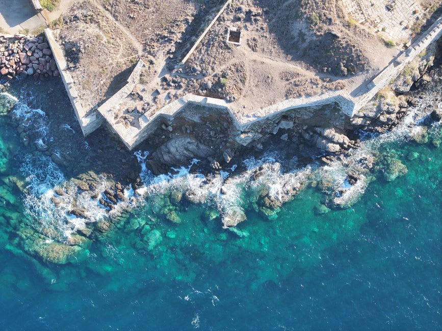 Clear turquoise water off the Enfeh peninsula with submerged ancient ruins visible below the surface