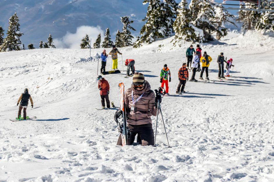Skiers descending a snow-covered slope at Faraya Mzaar with chairlifts overhead