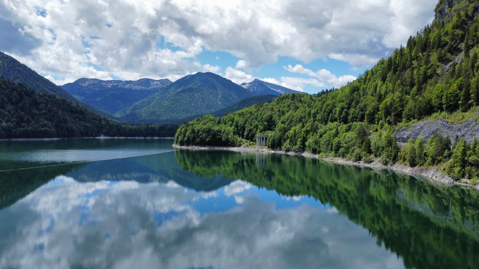 Stausee Steg reservoir with still water reflecting the surrounding pines