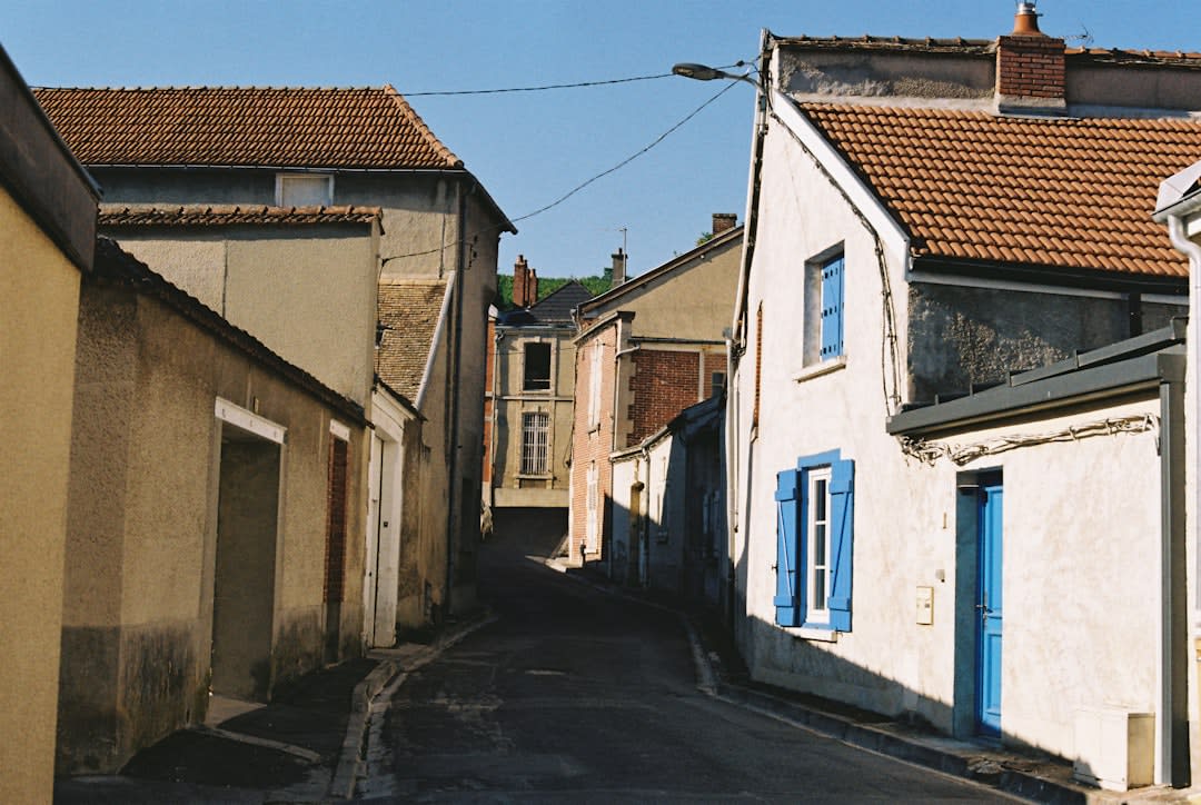 Una calle tranquila de tierra en Niafunké bordeada de edificios de adobe