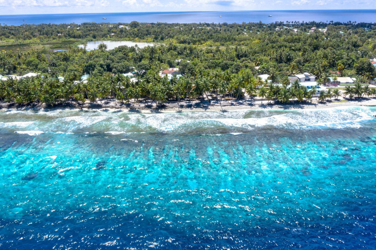 Looking through the reef passage into Arno's inner lagoon, the water shifting from deep indigo to turquoise within twenty meters