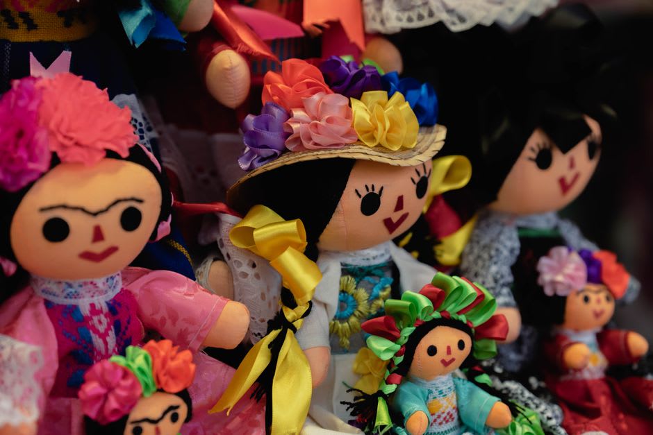 Muñecas de trapo otomíes exposées dans l'atelier coopératif d'Amealco, poupées cousues à la main en tenue traditionnelle hñähñu disposées sur une étagère en bois