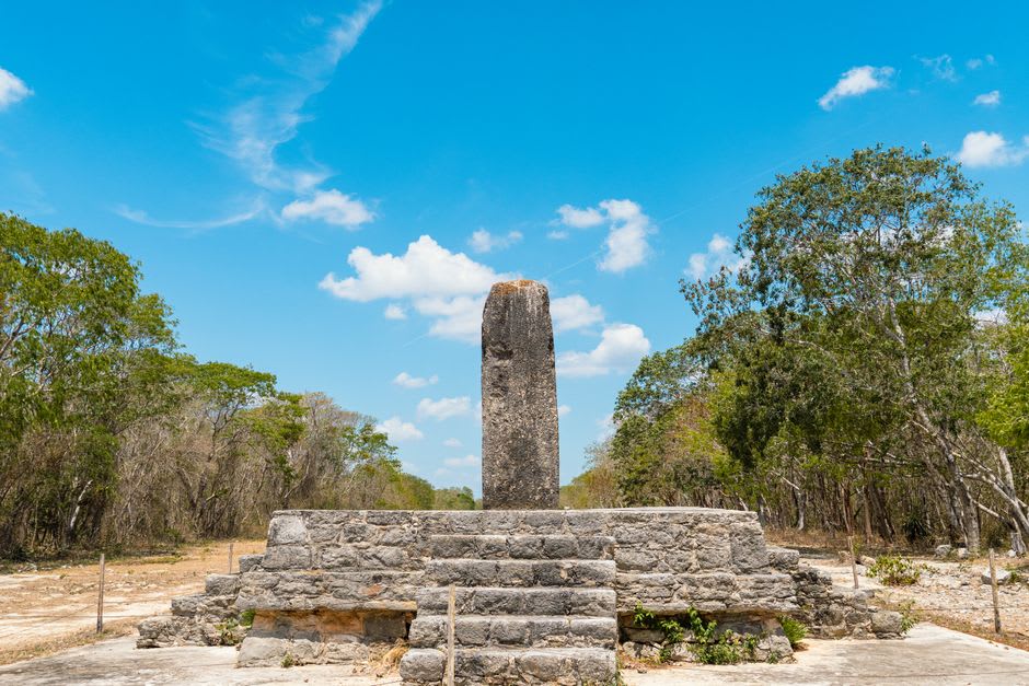 Estelas y plataformas de piedra en el sitio arqueológico de Pomoná, piedra tallada chontal maya bajo luz moteada de selva