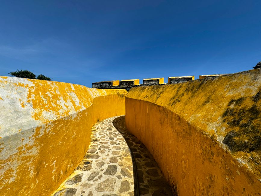 El portal en arco y la torre del Convento de San Luis Obispo vistos desde el atrio en Calkiní