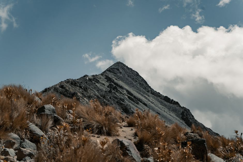 Les deux cerros jumeaux de Chalcatzingo s'élevant depuis la plaine du Morelos, les formations de roche volcanique se découpant sur un ciel dégagé