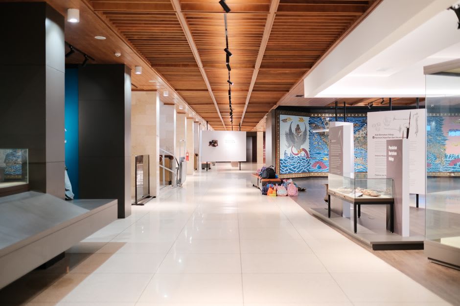 Amplio interior de galería del Museo de Arte de Sinaloa, techos altos y pisos de azulejo con fotografías de gran formato sobre muros blancos