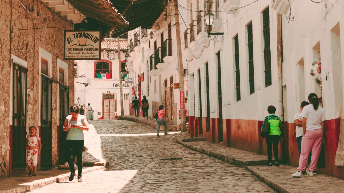 La ladera sobre El Oro con antiguas bocas de mina visibles entre los pinos, los techos de tejamanil del pueblo abajo, el pálido cielo gris invernal de las montañas del Estado de México arriba