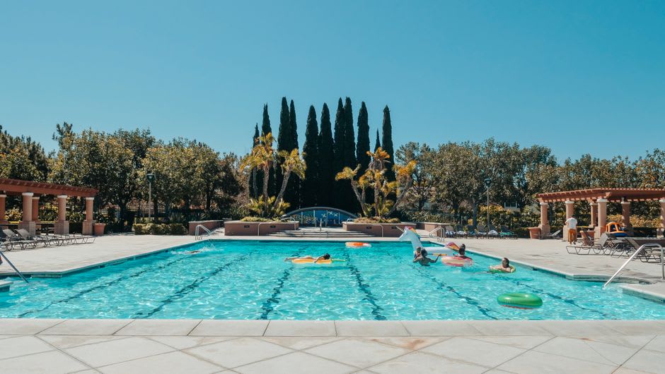 Albercas termales en el Balneario Municipal de Ixtapan de la Sal con agua verde mineral y bañistas bajo la luz cálida de la tarde