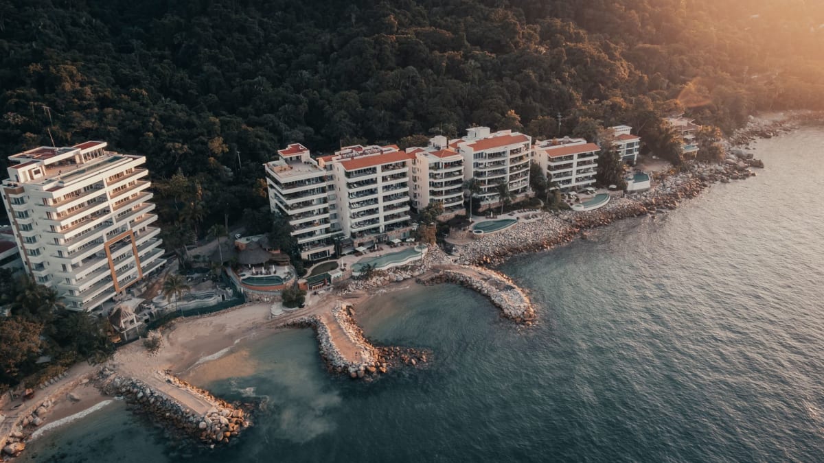 Playa La Audiencia dans la Bahía de Santiago de Manzanillo, le croissant de plage calme et protégé avec le complexe hôtelier visible en arrière-plan, le Pacifique visible autour du promontoire de Santiago, lumière d'après-midi sur la baie