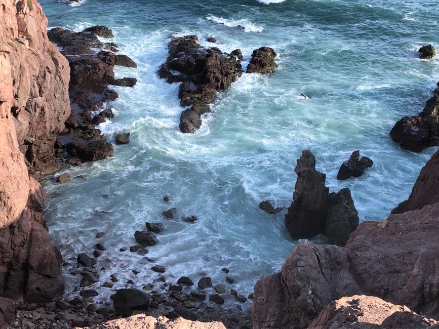 La costa del Pacífico en Mazatlán vista desde El Mirador, olas rompiendo en las rocas debajo del paseo del acantilado, la ciudad vieja y su catedral visibles a lo largo de la costa curva