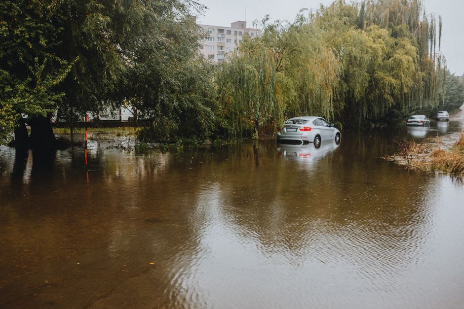Rue pavée inondée à Mexcaltitán avec un habitant pagayant dans une pirogue en bois devant des façades colorées
