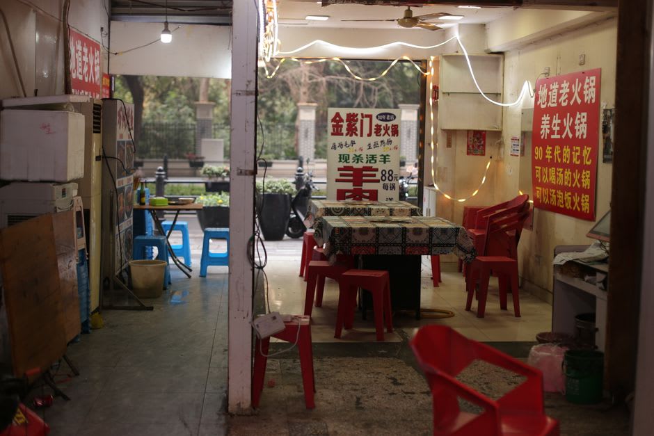 El interior de un restaurante de larga trayectoria en La Chinesca de Mexicali, mesas de fórmica y arte de calendarios chinos antiguos en las paredes