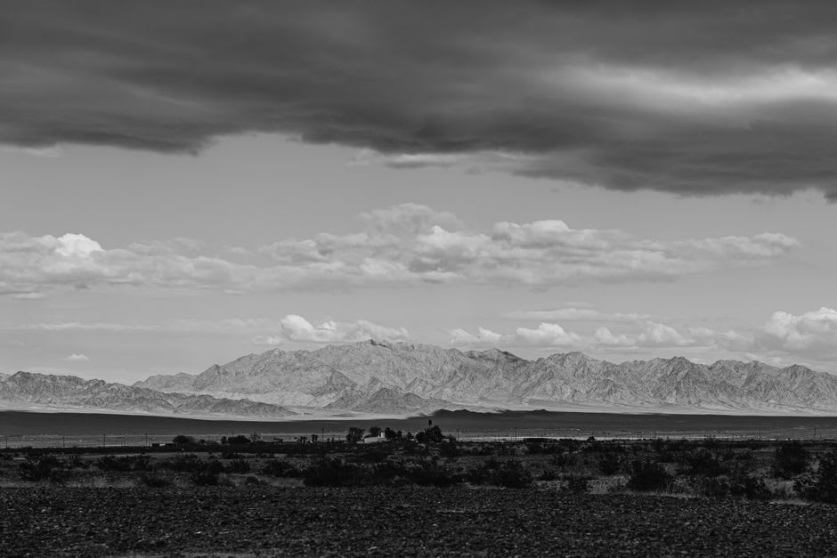 El plano Desierto Chihuahuense al norte de Múzquiz al atardecer, sierra aislada en la distancia, vegetación desértica capturando la última luz