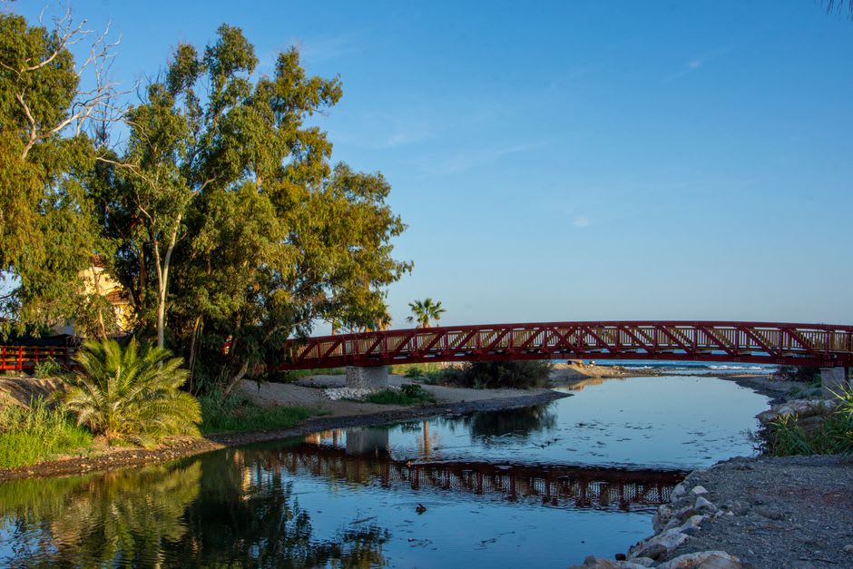 El Río Bravo visto desde el malecón de Piedras Negras a última hora de la tarde, el puente de Eagle Pass al fondo y el río reflejando un cielo pálido