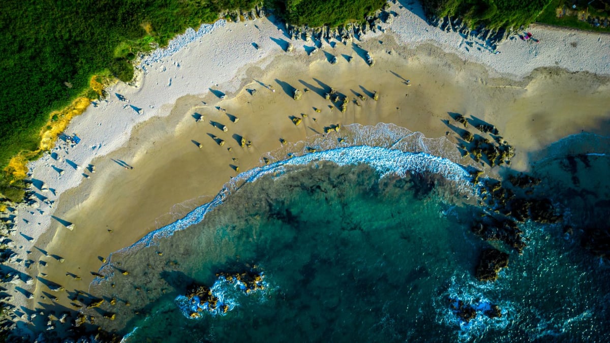 Le trou souffleur d'El Morro près de Punta Mita, une colonne d'eau blanche jaillissant par l'ouverture étroite dans la roche volcanique, le Pacifique bleu tout autour, une panga à distance de sécurité