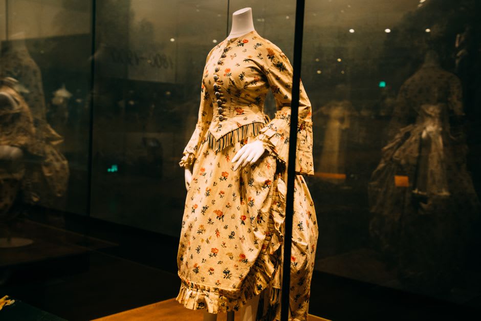 Una vitrina en el museo de Lola Beltrán con fotografías y vestuario de escenario, luz natural de una ventana que da a la plaza