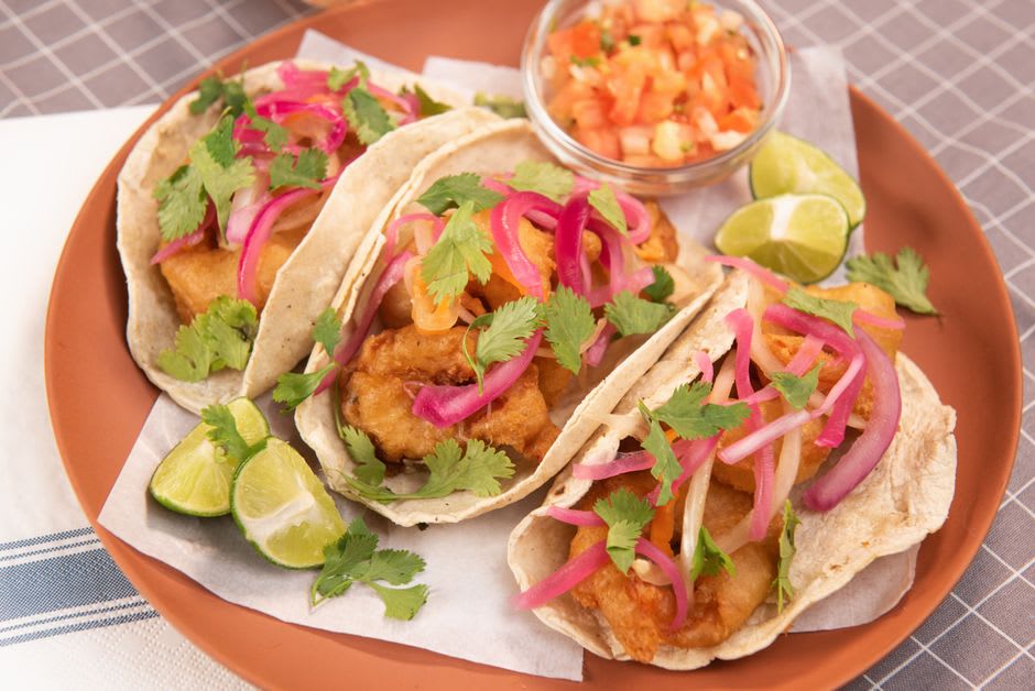 Puestos de tacos coloridos y vendedores ambulantes a lo largo de la avenida Benito Juárez en el centro de Rosarito, una tarde entre semana tranquila