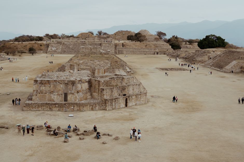 Stone pyramid platforms at Teotenango photographed from the main plaza, the volcanic hill landscape visible beyond the ruins and the sky clear and cold above