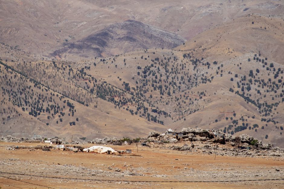 La roche sédimentaire stratifiée du pays fossilifère dans les collines sèches près de Tepexi de Rodríguez, strates de pierre pâle exposées sur un versant sous un vaste ciel semi-aride