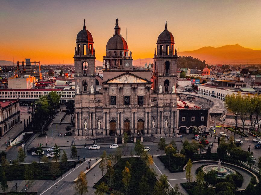 Toluca's central plaza in the morning, the cathedral visible behind the Portal Madero arcade with its colonial arches