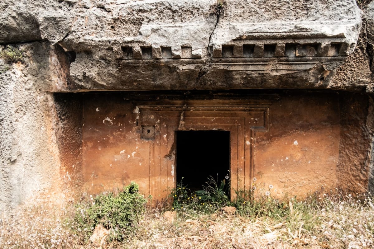 Ancienne porte de colonne de basalte dans les ruines de Lelu à Kosrae encadrée par la végétation tropicale avec une lumière tachetée filtrant à travers la canopée de la jungle