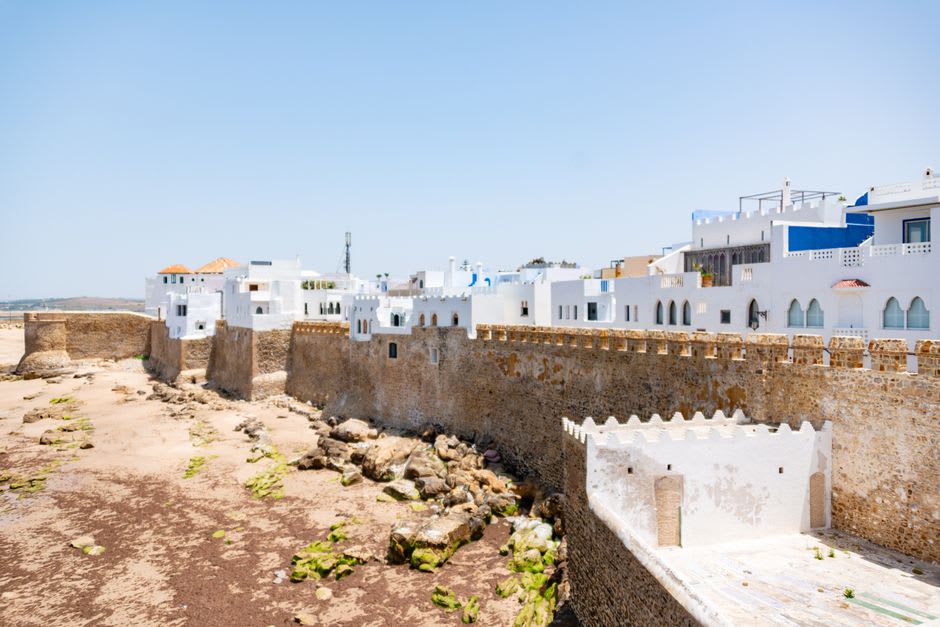 Les remparts portugais d'Asilah dominant la côte atlantique, la vieille pierre captant la lumière de l'après-midi sous un ciel bleu dégagé.