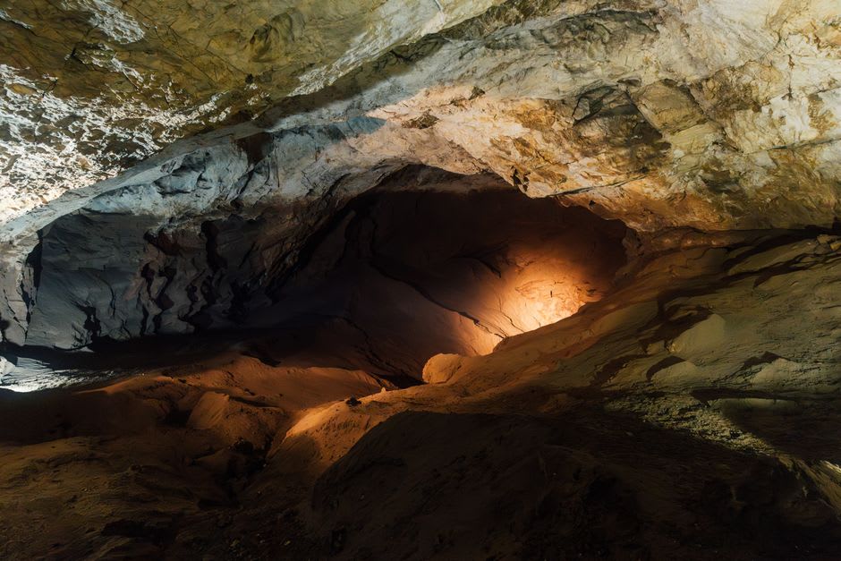 Pilgrims descending the damp, narrow limestone steps inside Gupteshwor Cave toward the underground shrine