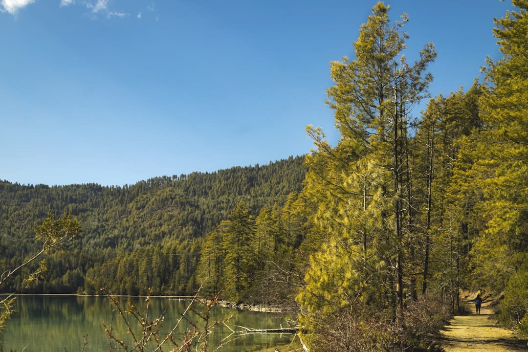 Sommets enneigés se reflétant sur la surface immobile du lac Rara à l'aube
