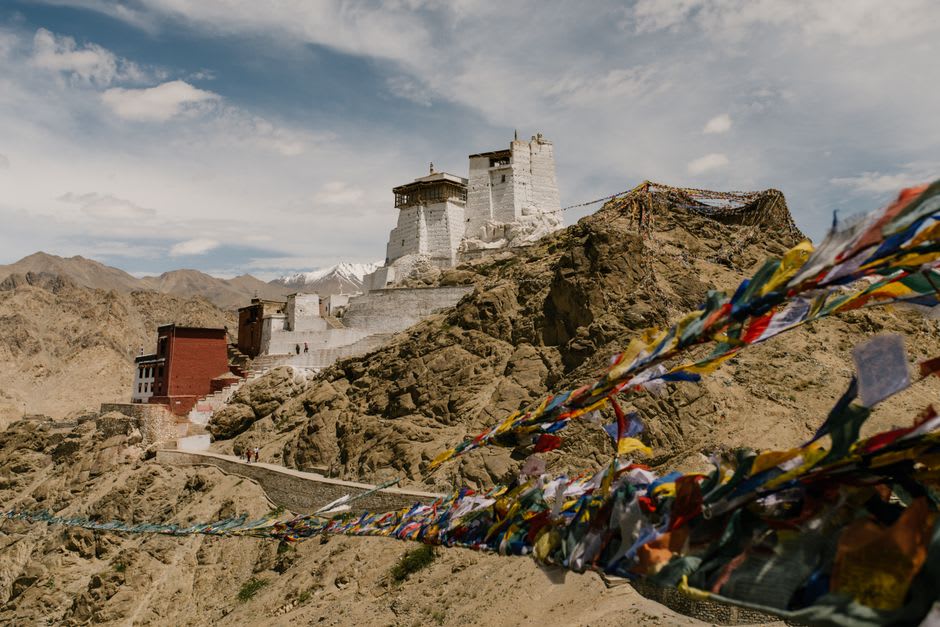Banderas de oración y un pequeño gompa de piedra en el extremo alto de Thulo Syabru con vistas a las laderas escalonadas