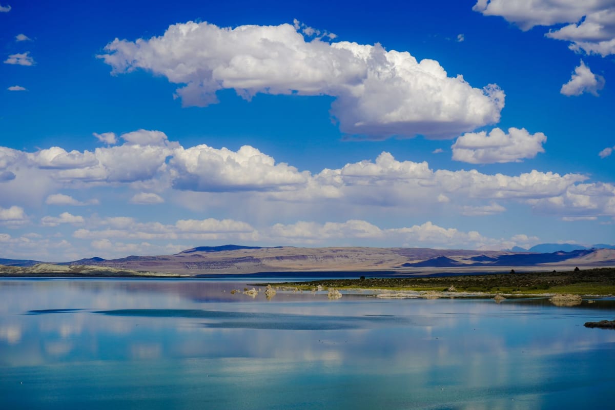 La superficie plana como un espejo del Lago Baker sobre la línea de árboles, con Wheeler Peak reflejado en el agua quieta