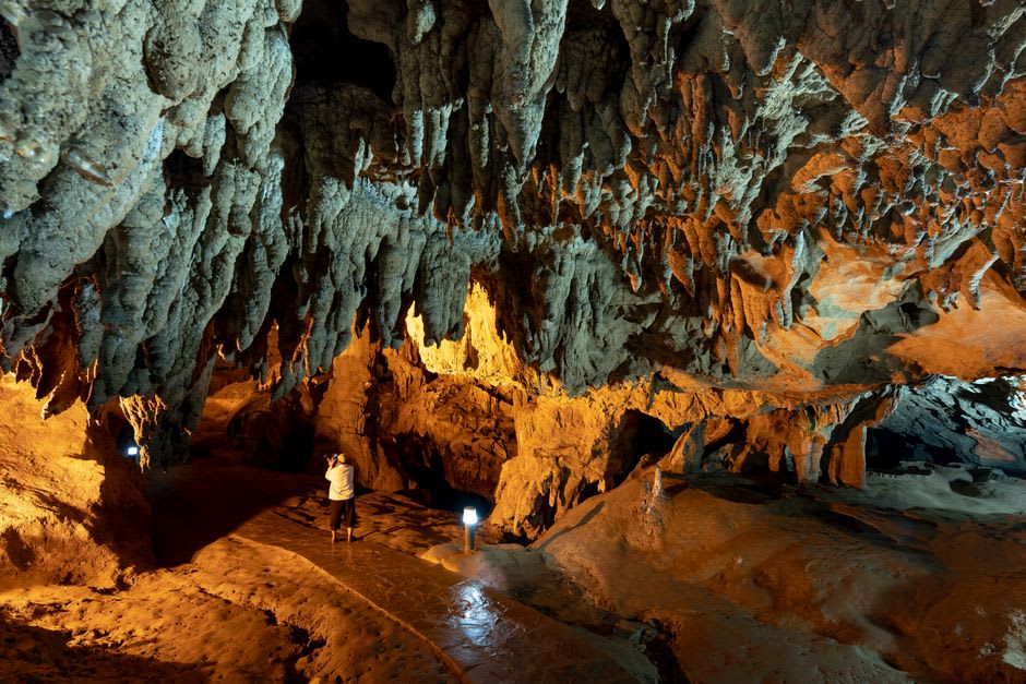Torchlight illuminating a limestone chamber inside Ogbunike Caves