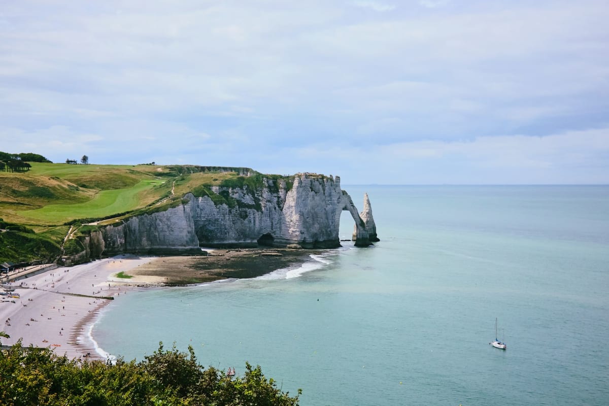 El arco de tiza de la Falaise d'Aval con la aguja Aiguille emergiendo del mar, Étretat