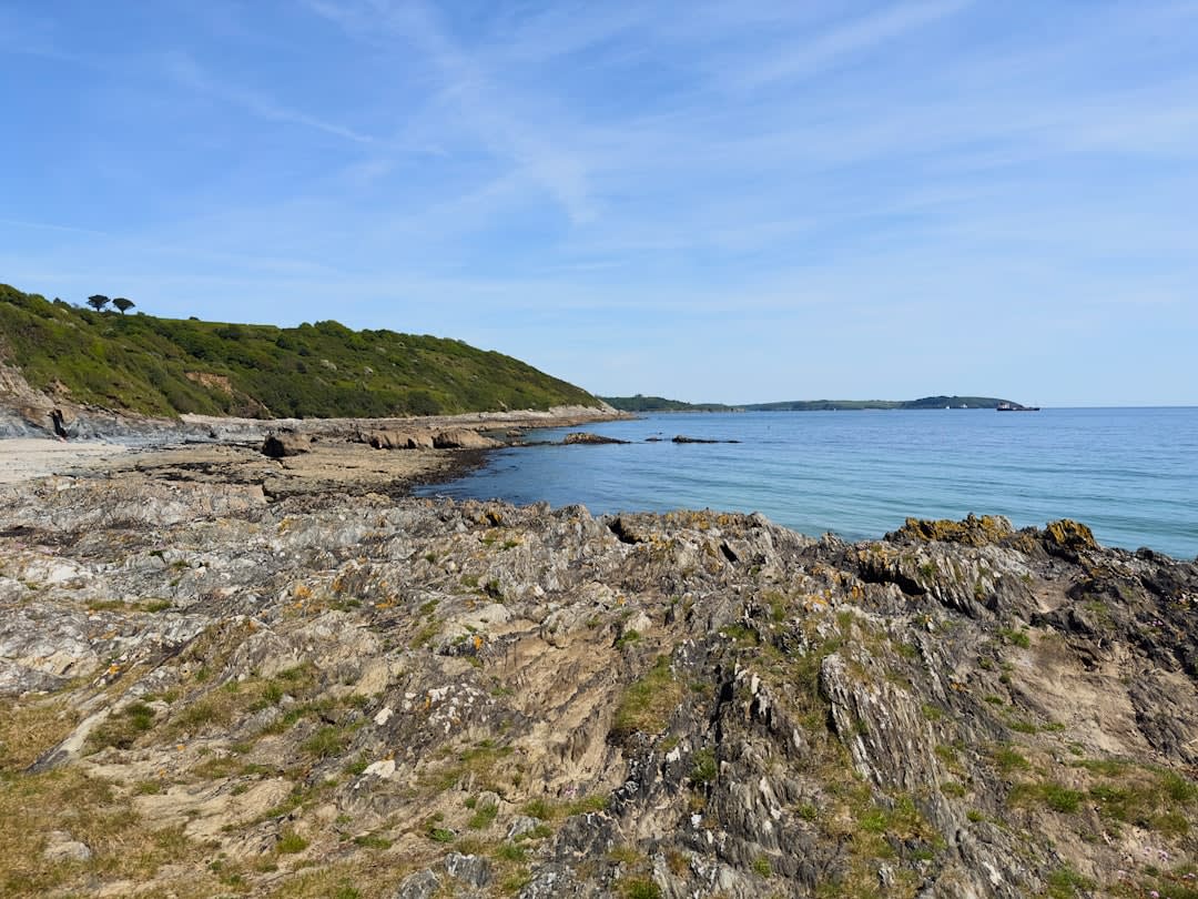 Rows of bomb craters covered in grass stretching across the Pointe du Hoc clifftop toward the sea