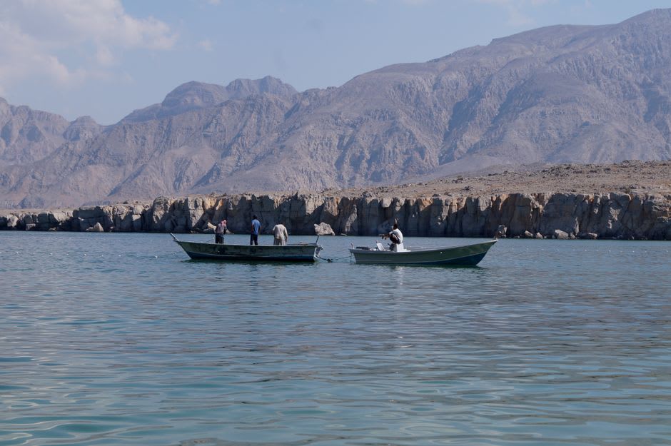 Dramatic bare cliffs meeting the deep blue Arabian Sea along the coast near Al Jazir, Oman