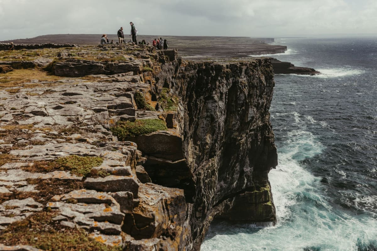 El faro de Noup Head en Westray con los acantilados de arenisca y las pilas marinas extendiéndose hacia el sur a lo largo de la costa