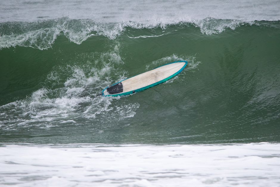 Surfers paddling out into the Atlantic swell at Reef Beach near Uig